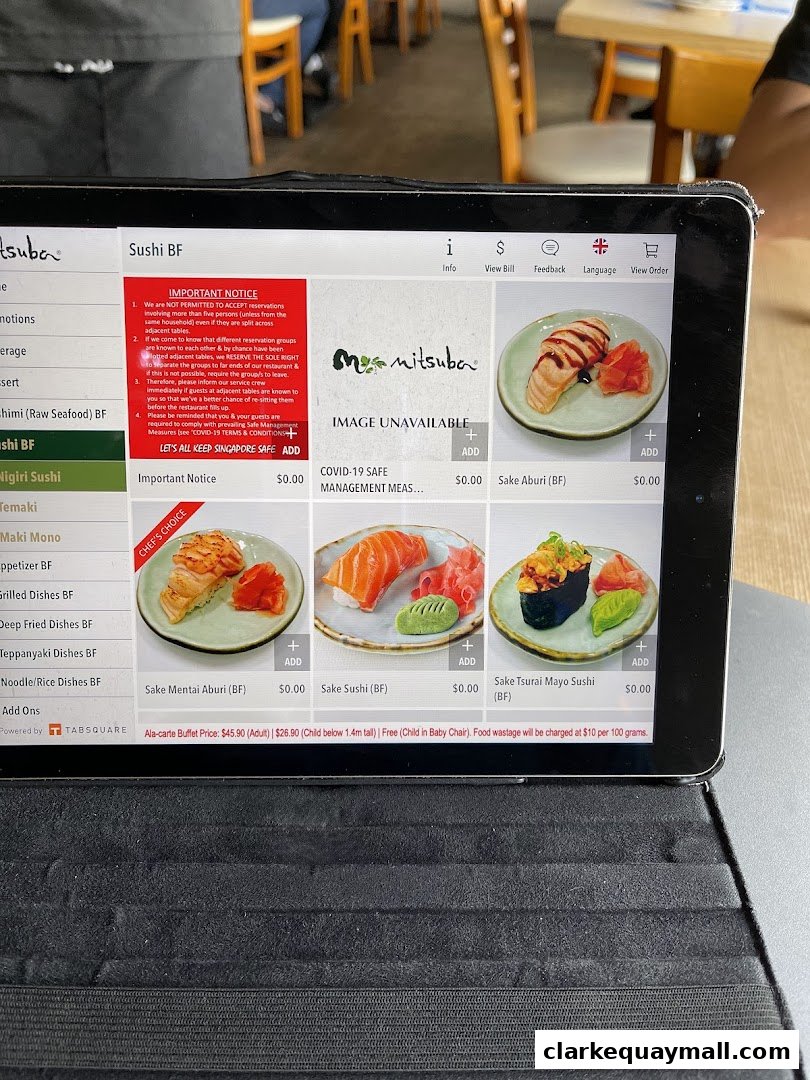 A tablet displays a digital menu for Mitsuba Japanese Restaurant, showcasing sushi dishes.