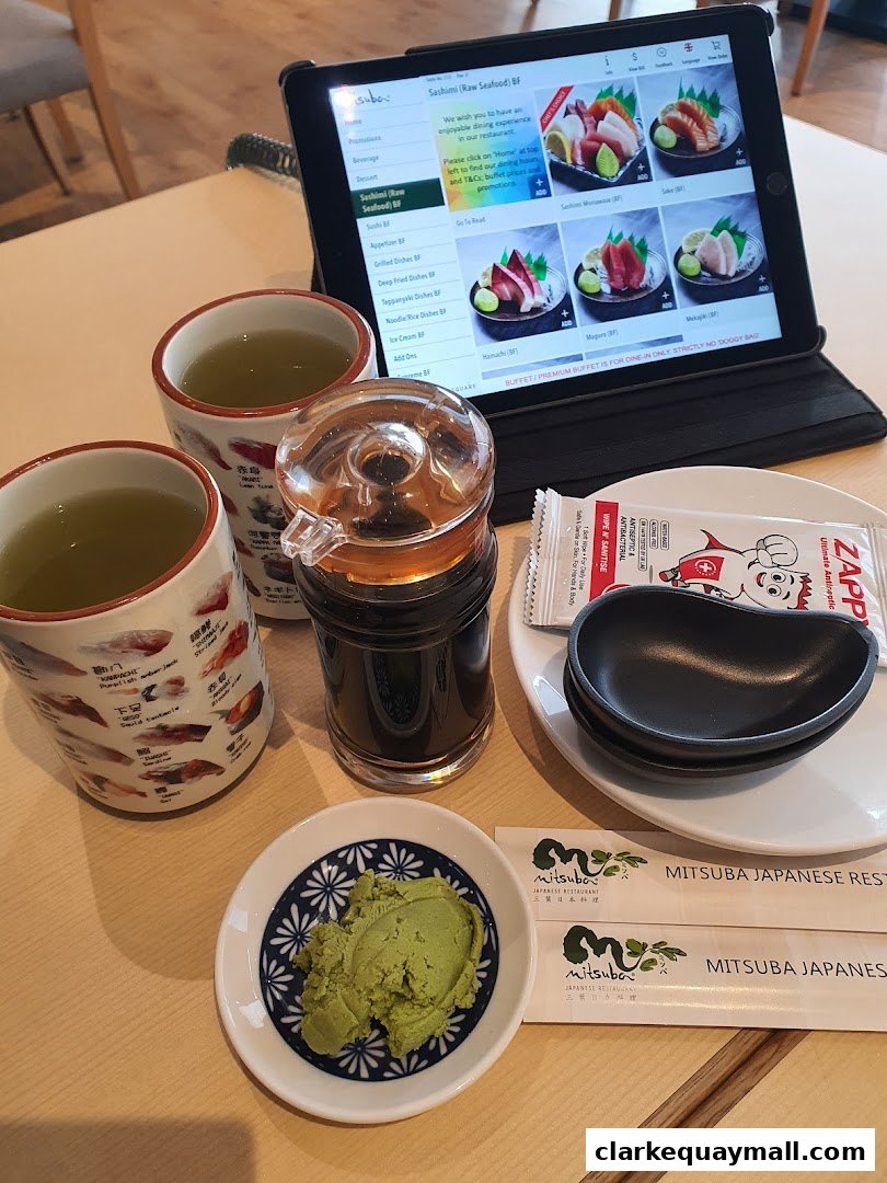 A tablet displays a Japanese restaurant menu with sashimi options and accompanying tea and wasabi.