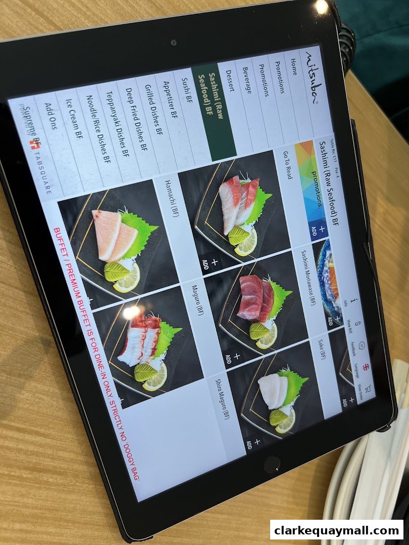 A tablet displaying a digital menu for Mitsuba Japanese Restaurant, featuring sashimi dishes.