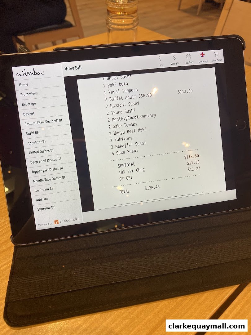 A tablet displaying a bill for Mitsuba Japanese Restaurant with various sushi and buffet items.