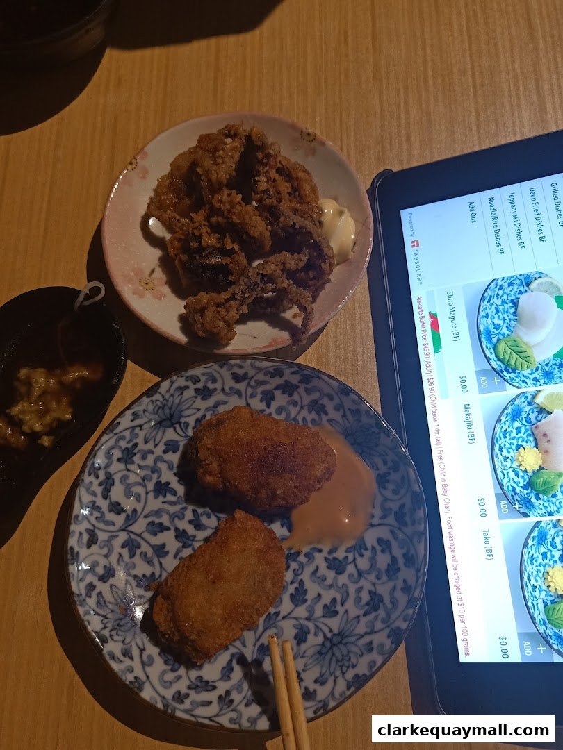 A close-up of Japanese fried dishes and a tablet displaying a menu.
