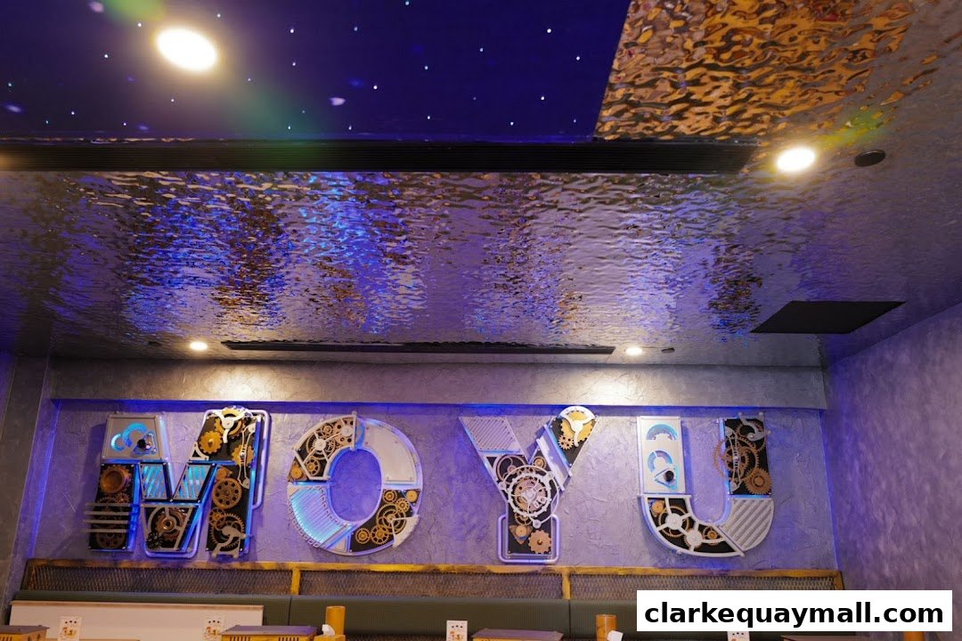 Interior shot of a restaurant with large, illuminated letters spelling 'MOYU' on the wall.