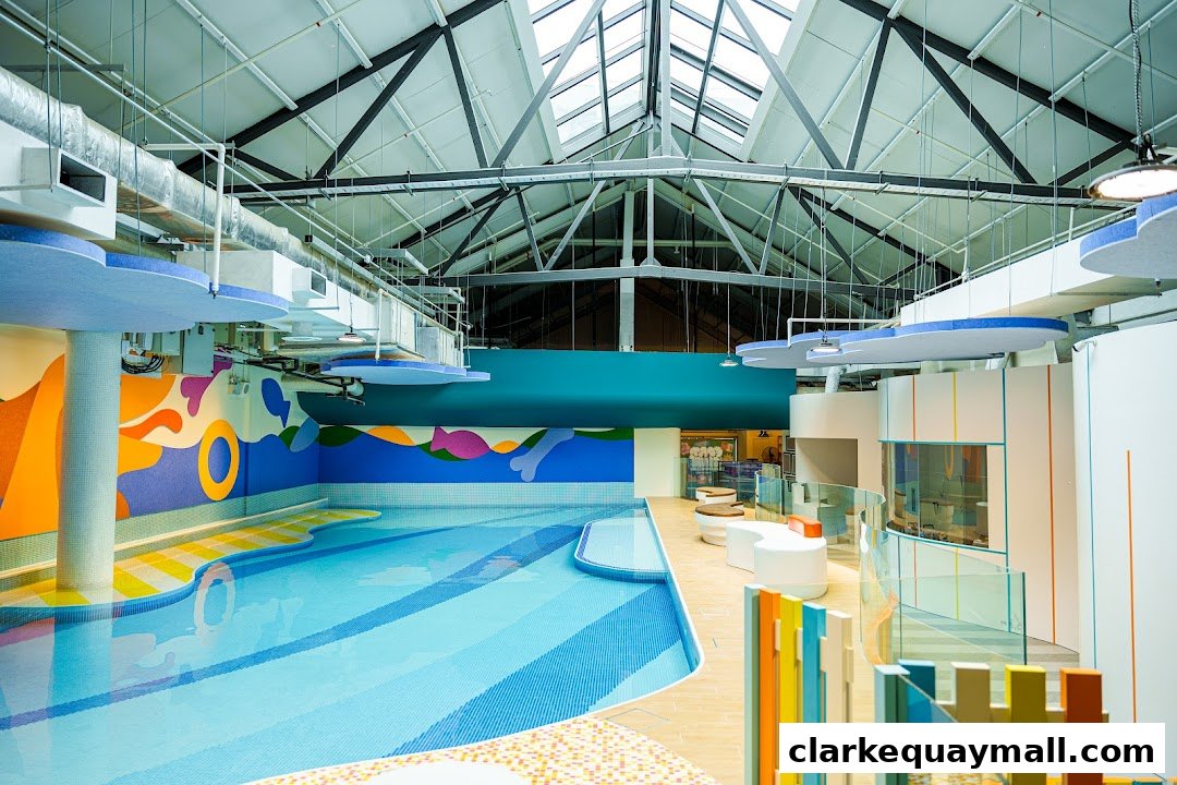 A brightly colored indoor swimming pool area with modern seating and playful wall art.