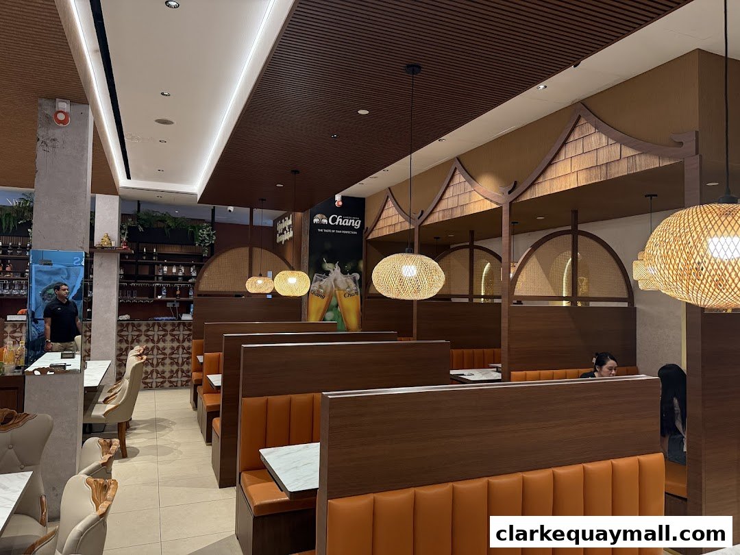 Interior view of a Thai restaurant with booth seating and decorative lighting.