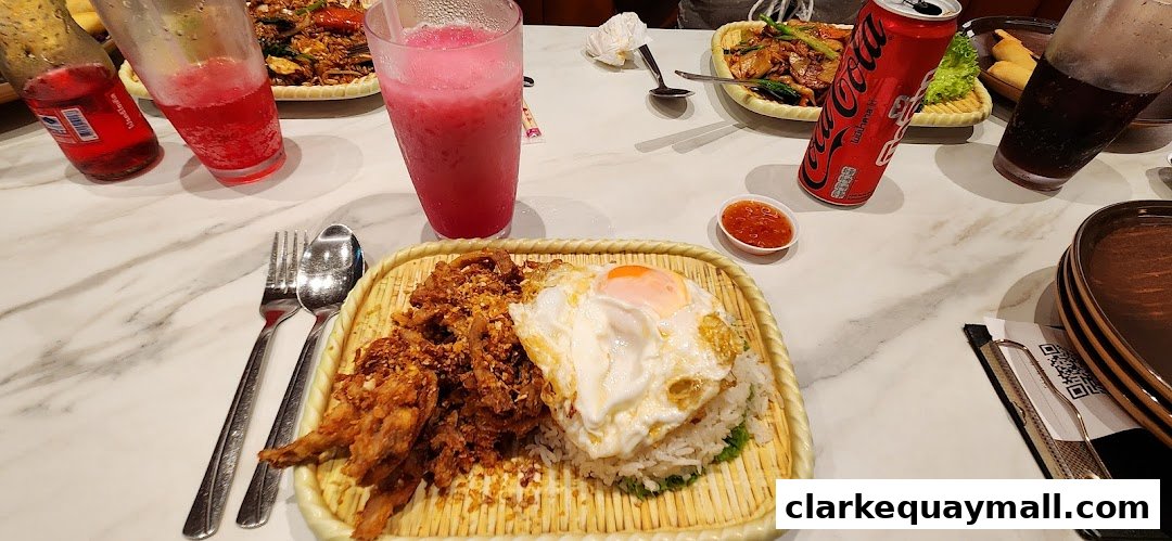 A table at Nana Thai Royale Clarke Quay with Thai food, drinks, and cutlery.