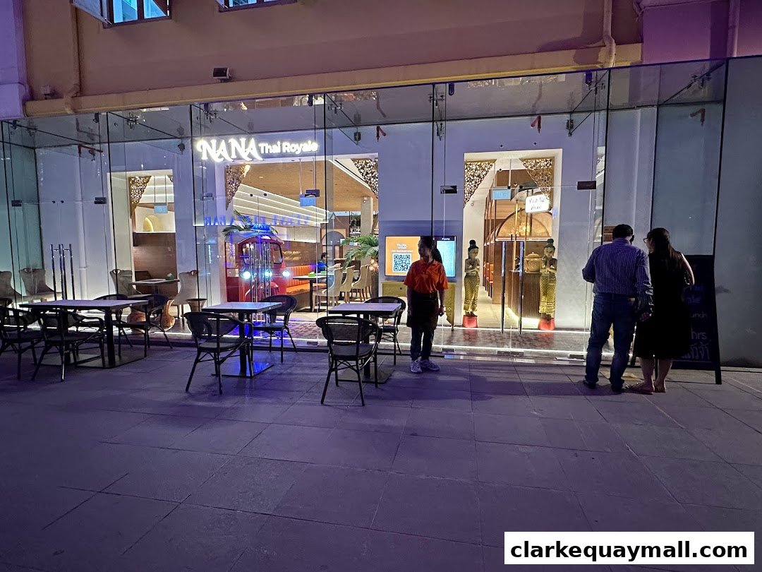 The exterior of Nana Thai Royale restaurant at night, with outdoor seating and people entering.