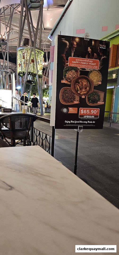 A sign advertising Nana Thai Royale's Happy Family Feast with images of Thai dishes.