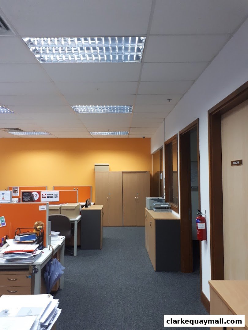 An office interior with desks, cabinets, and a fire extinguisher visible.