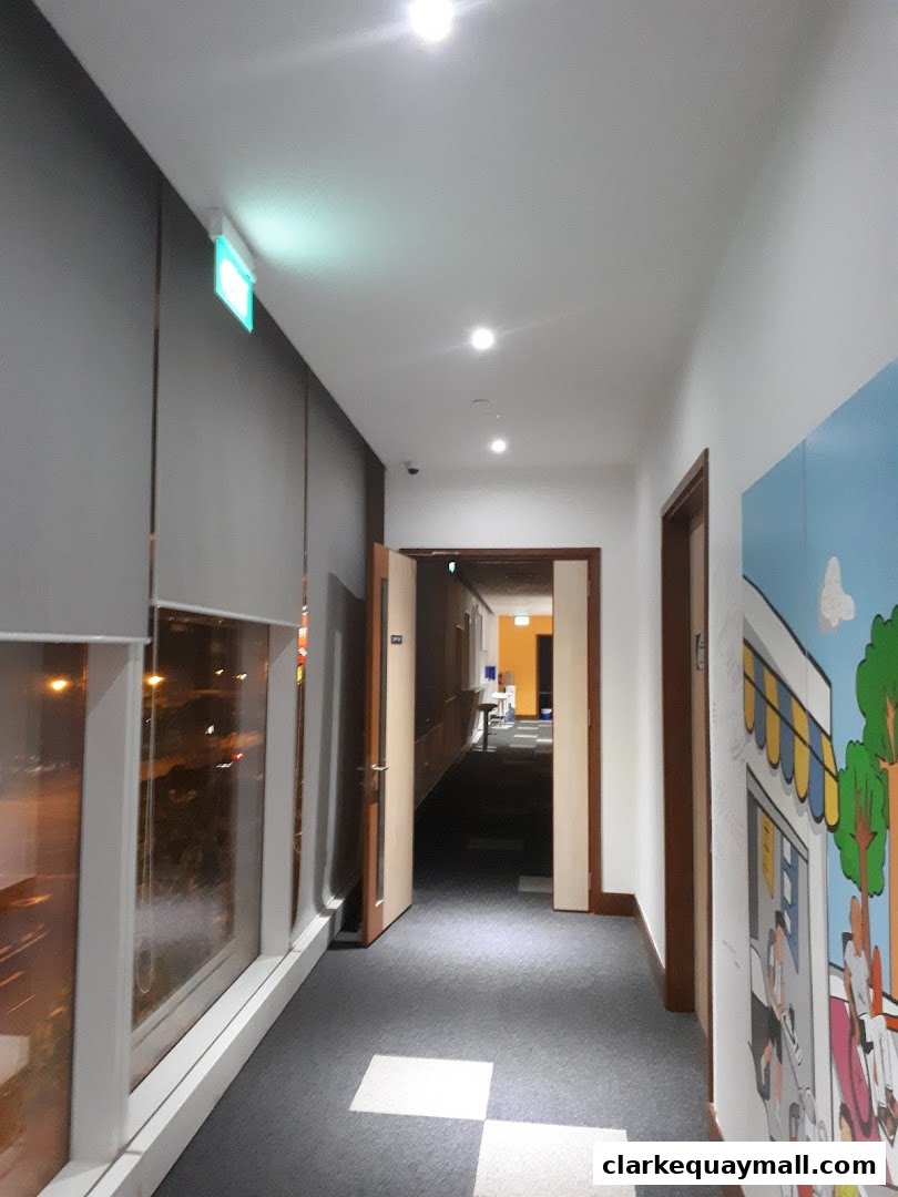A hallway with doors, windows, and a mural on the right wall.