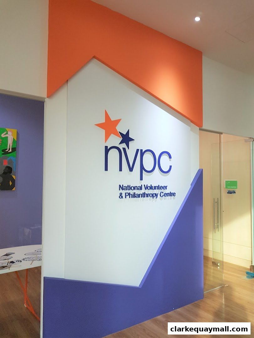 The National Volunteer & Philanthropy Centre logo is displayed on a white wall with orange and purple accents.
