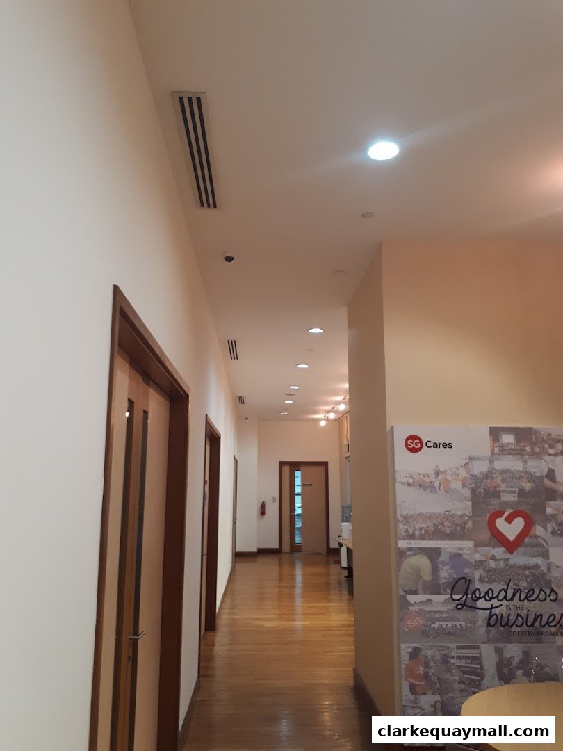 A hallway with doors and a motivational poster on the right wall.