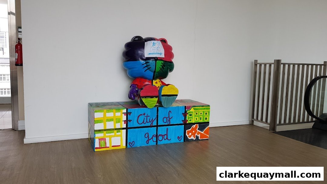 A colorful art installation featuring a teddy bear on a block base with 'City of Good' text.