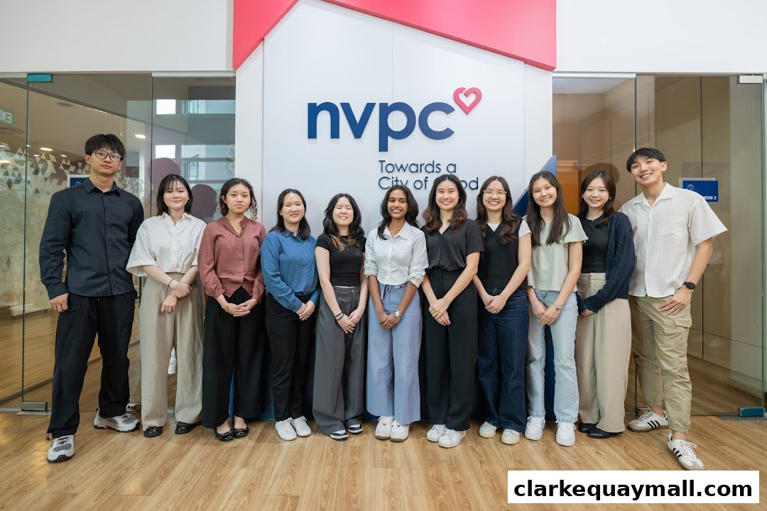 A diverse group of young people stand in front of the NVPC logo, smiling.