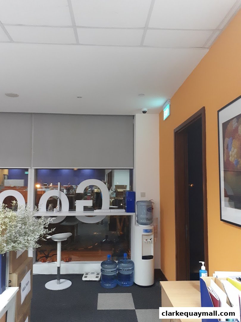 Interior view of an office space with a water cooler, seating, and artwork.