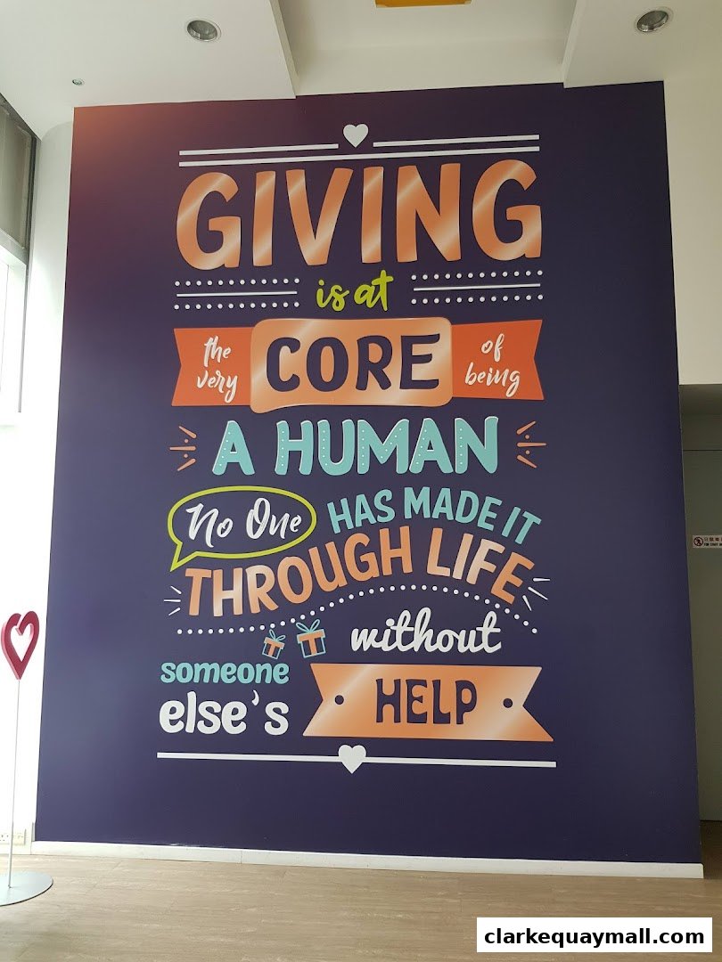 A large mural with the inspirational quote 'Giving is at the very core of being a human. No one has made it through life without someone else's help.'