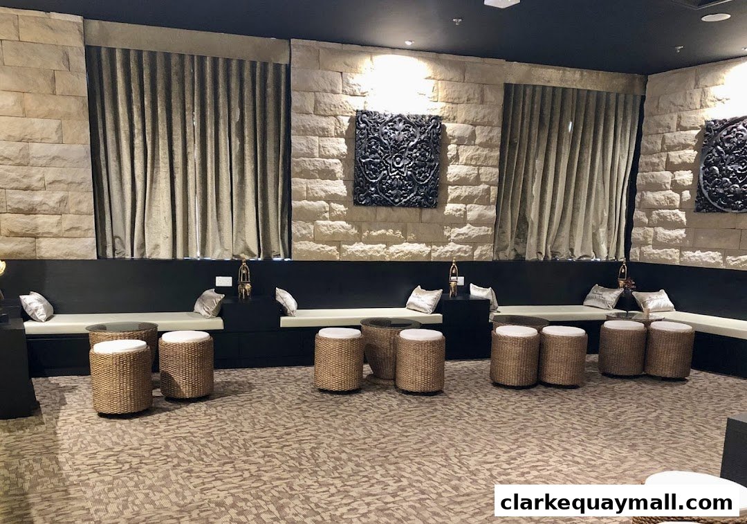 A waiting area with stone walls, plush seating, and woven stools.