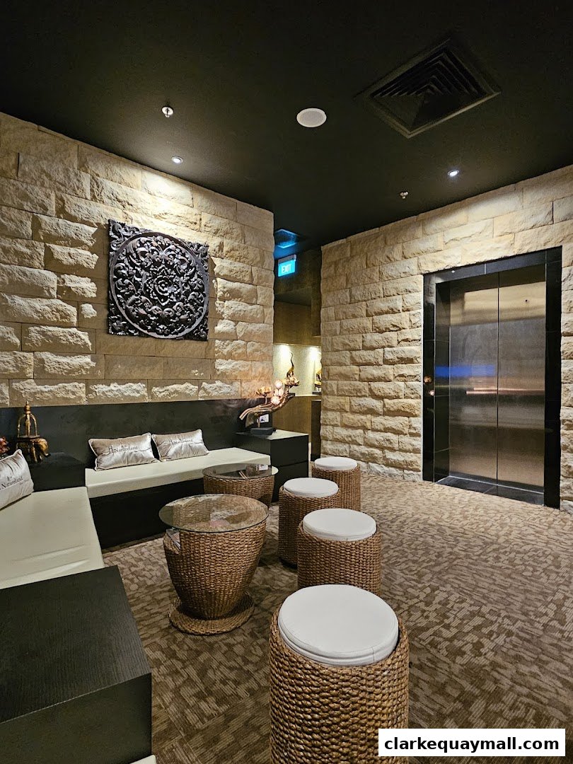 A waiting area with stone walls, comfortable seating, and woven stools.