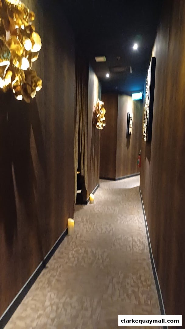 A dimly lit hallway with decorative lighting and candles, leading to treatment rooms.