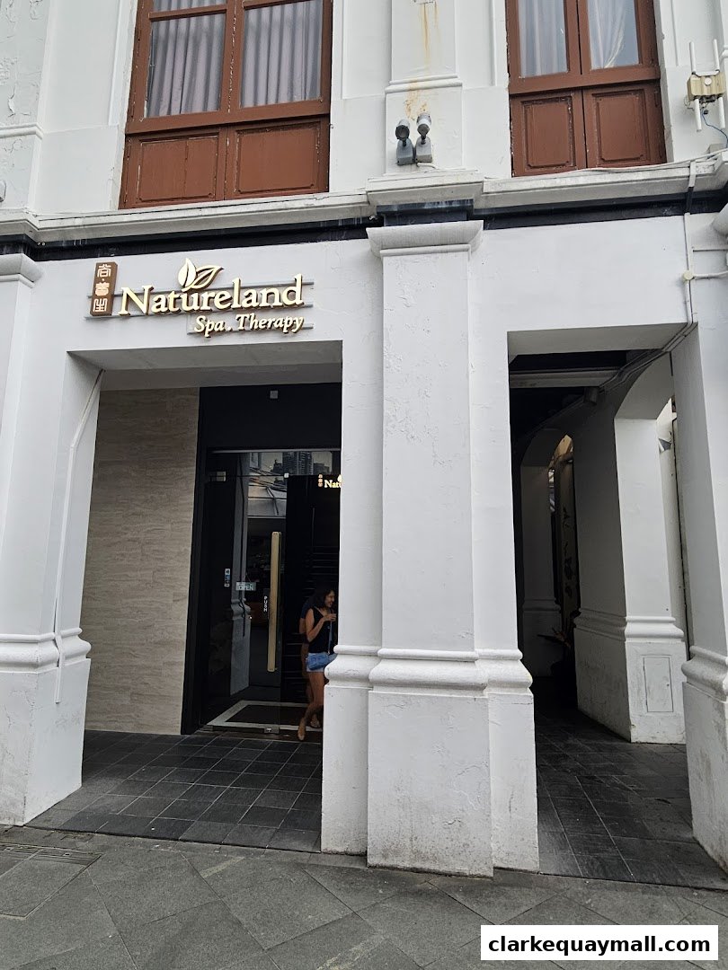 The entrance to Natureland Spa Therapy, a modern spa with a prominent golden sign.