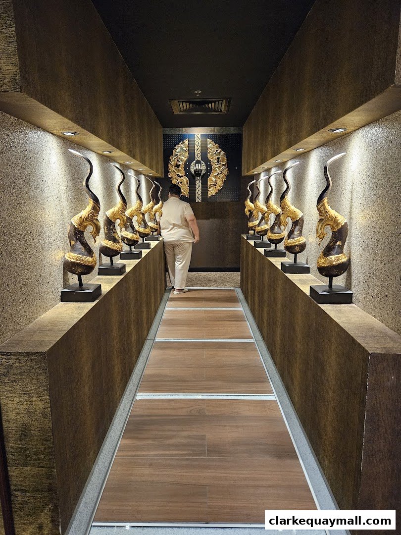A person walks down a hallway decorated with ornate golden sculptures and textured walls.