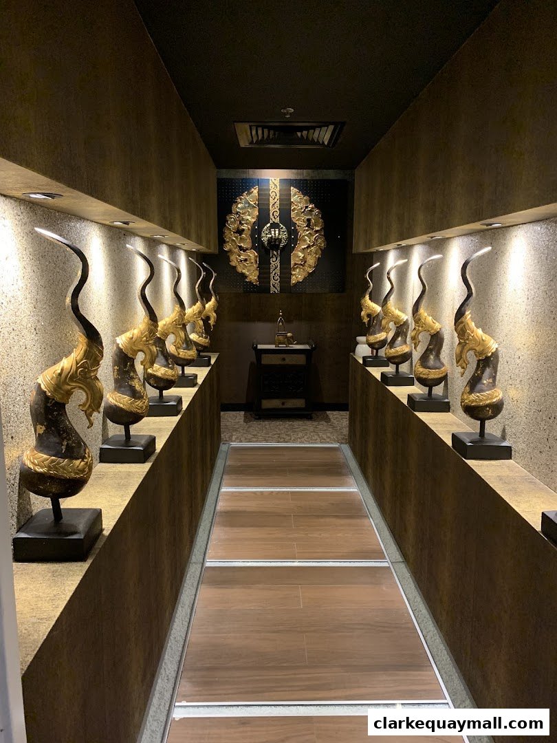 A dimly lit hallway with ornate golden statues and a decorative wall piece.