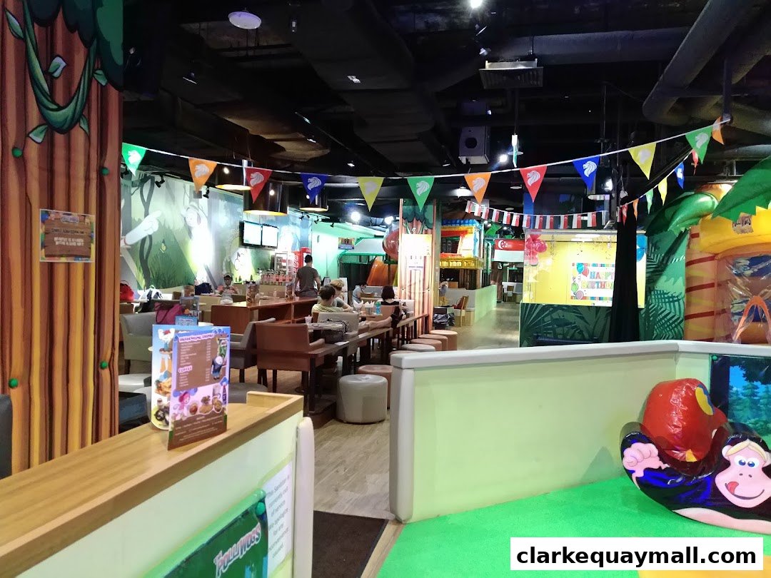 Interior of a colorful indoor playground with seating areas and play structures.