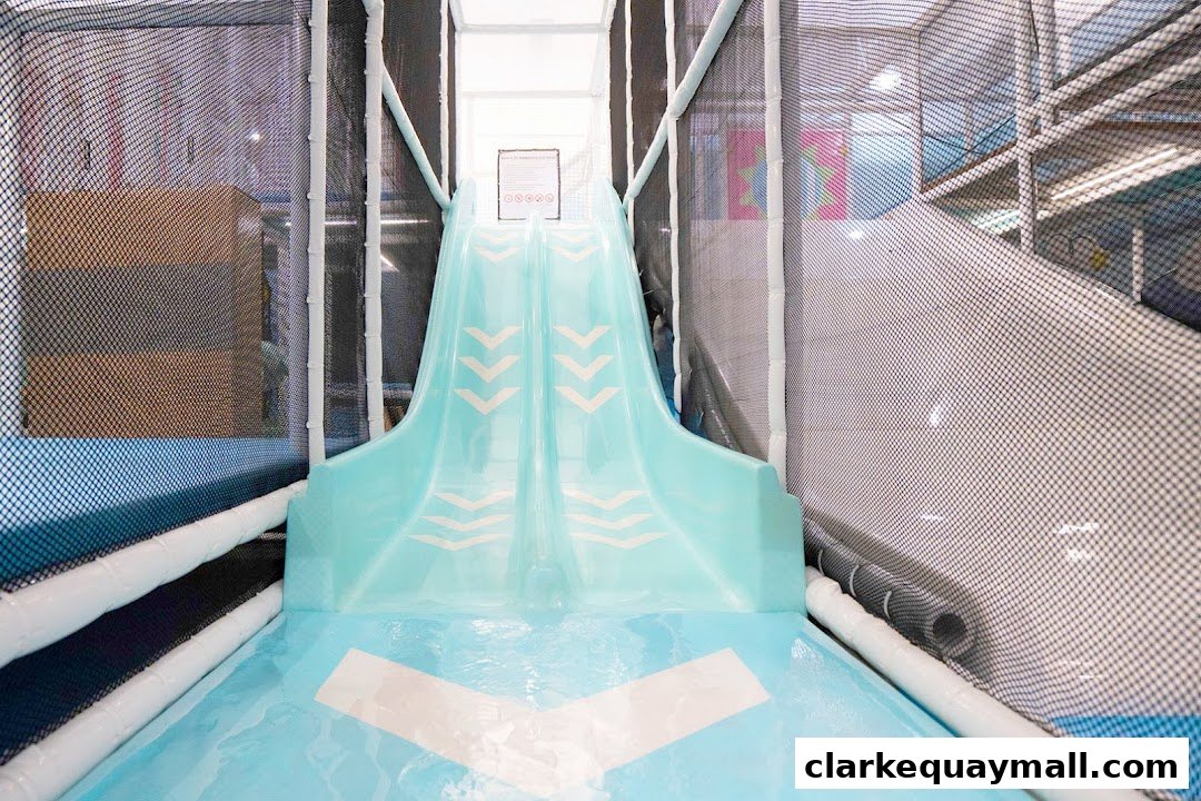 A bright blue slide with white chevron markings inside a play area.