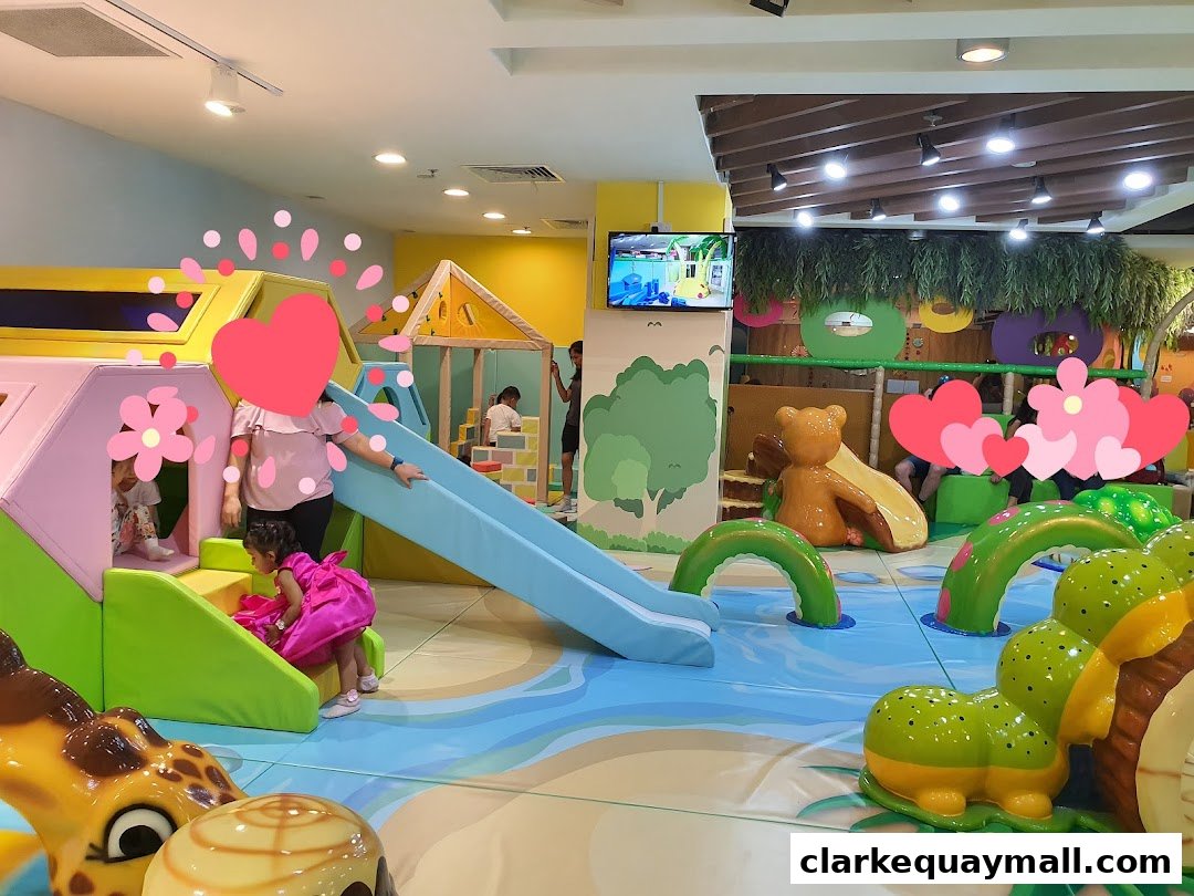 A vibrant indoor playground with slides, climbing structures, and playful animal-themed elements for children.