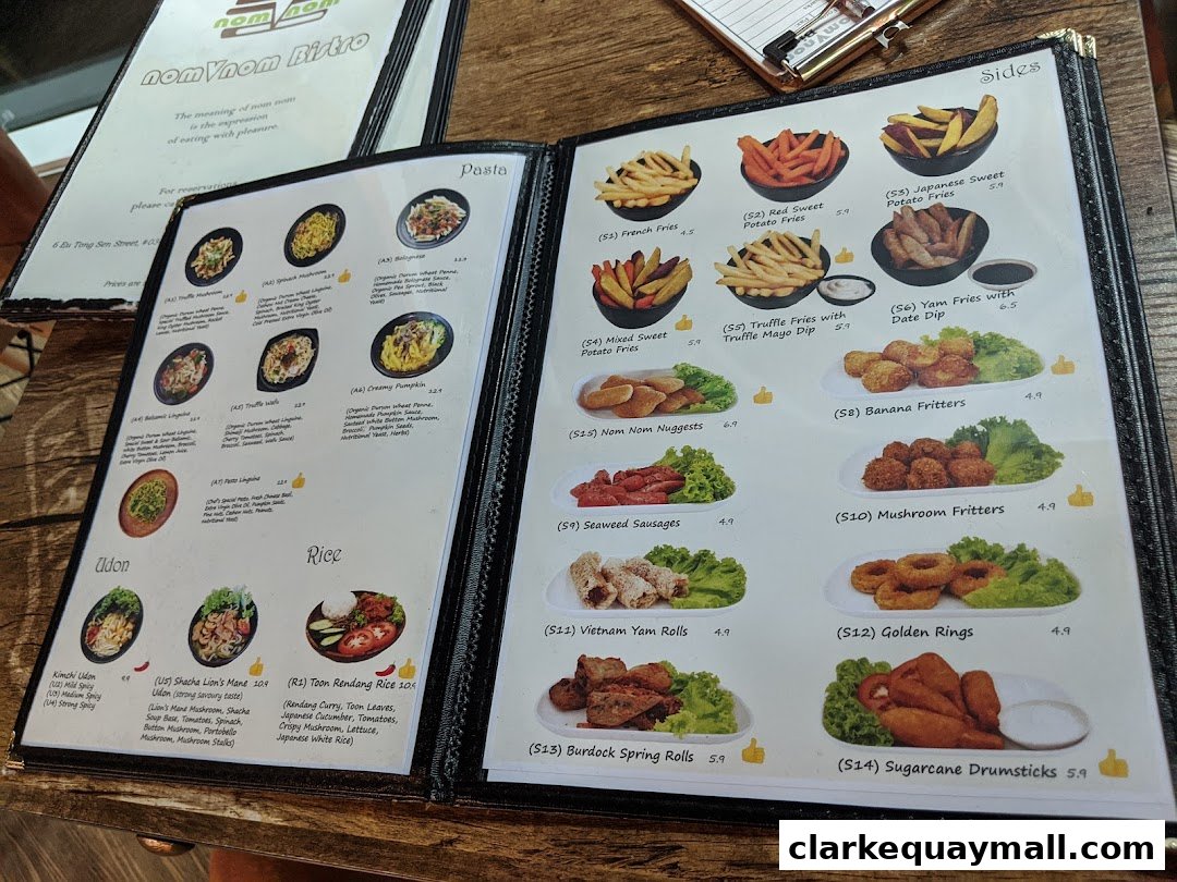 A menu from nomVnom Bistro featuring pasta, udon, rice, and various sides like fries and fritters.