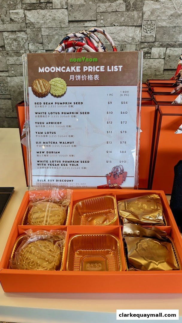 A price list for mooncakes from nomVnom Bistro, displayed with a box of mooncakes.