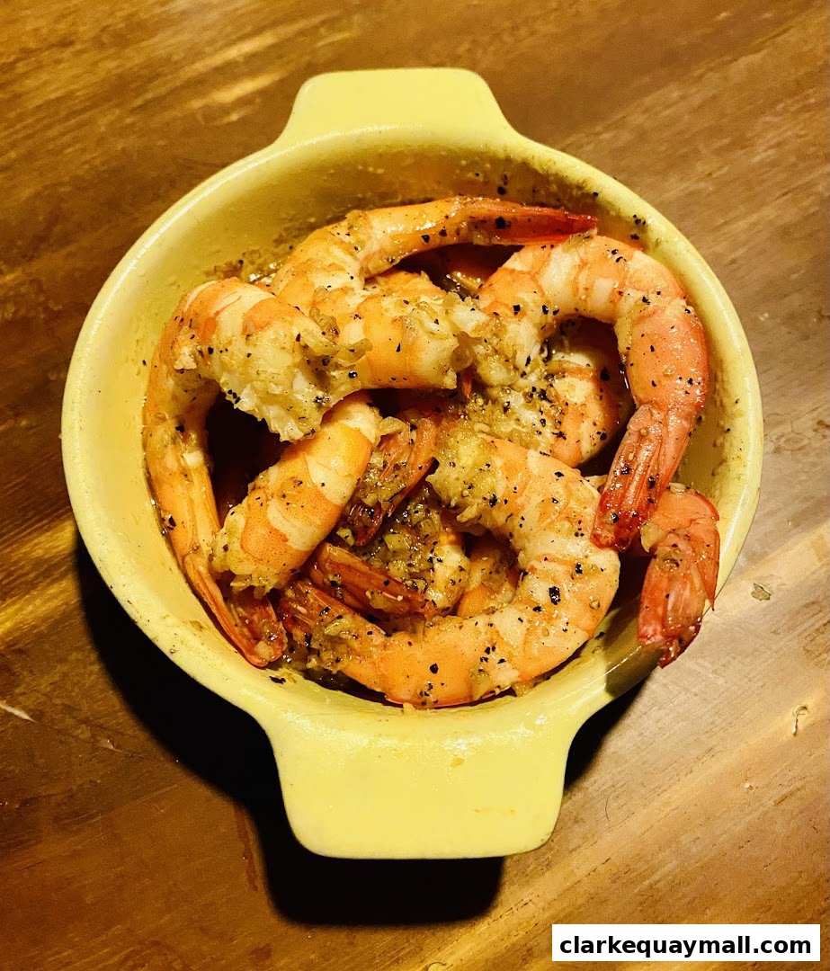 A close-up shot of a yellow dish filled with succulent, seasoned shrimp.