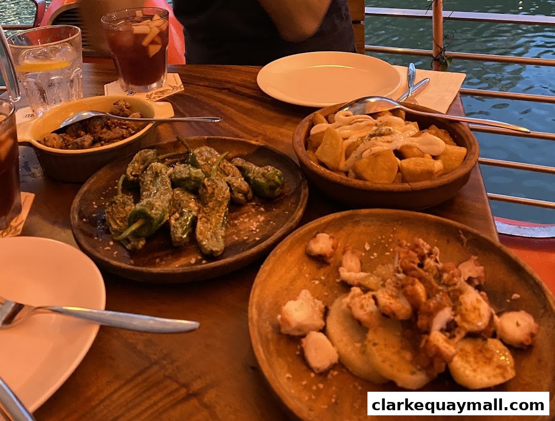 A table laden with various tapas dishes and drinks, suggesting a dining experience.