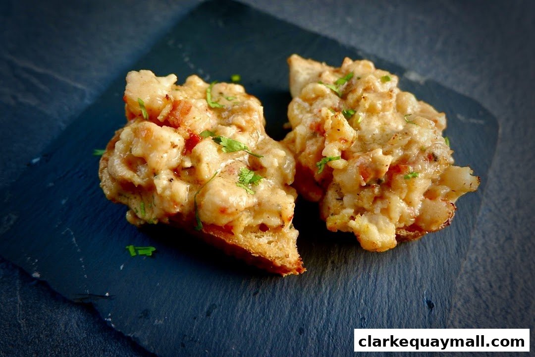Two pieces of tapas with creamy topping and herbs on a dark slate plate.