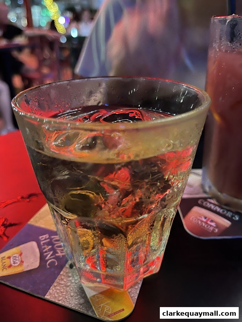 A close-up of a glass of iced drink with a coaster from Octapas.
