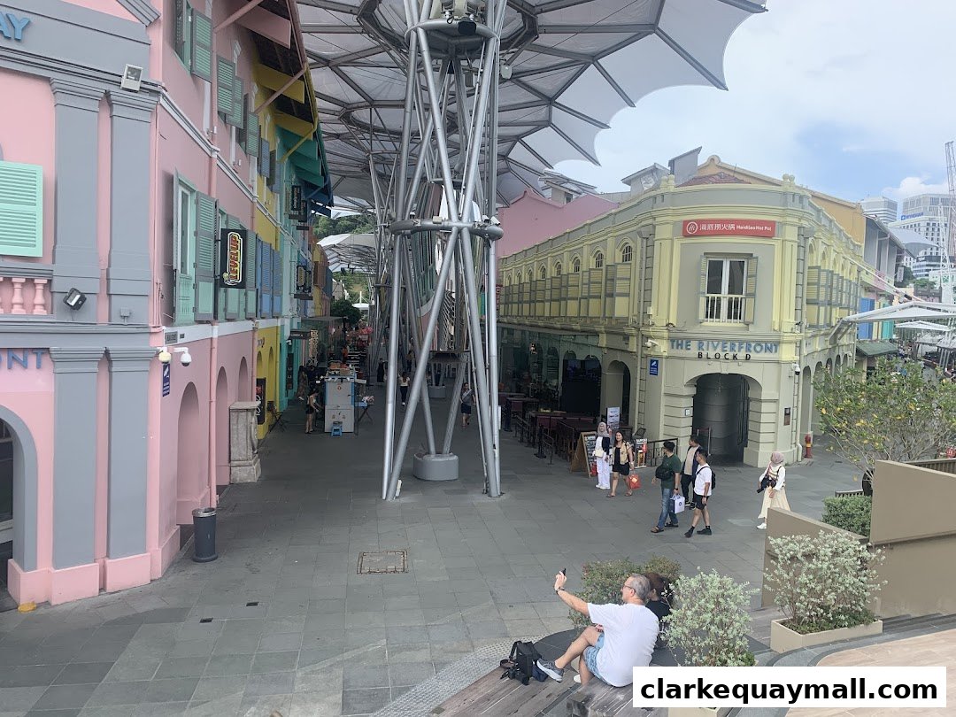 A street scene with colorful buildings and people walking along a covered walkway.