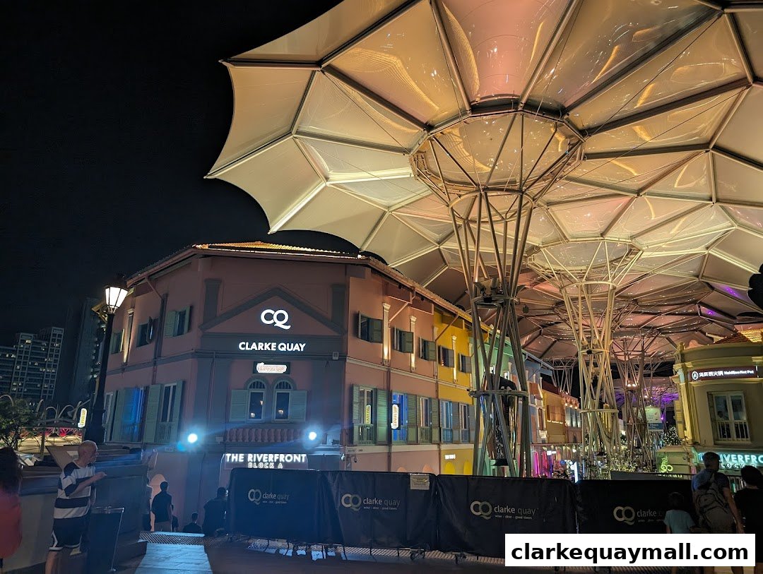 Night view of colorful buildings and a modern canopy structure at Clarke Quay.