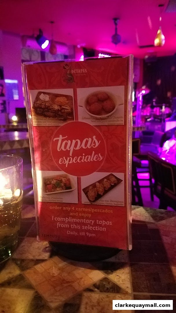A menu stand for Octapas International Tapas Bar with pictures of tapas.