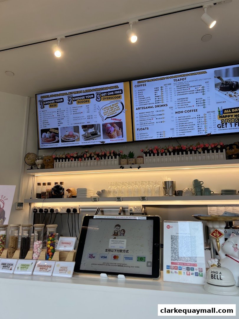 A digital menu board displays waffle and drink options, with a payment tablet and QR code below.
