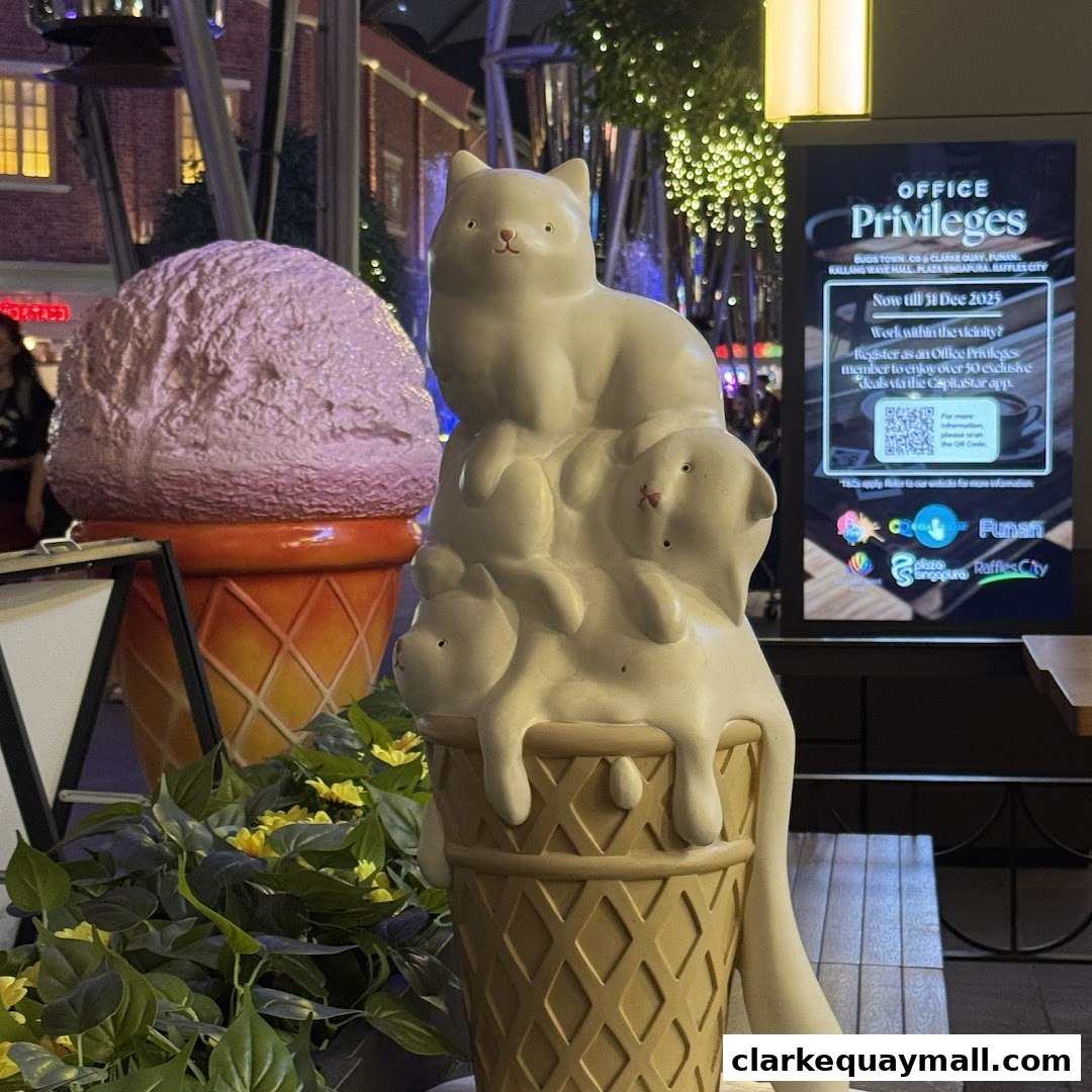 Giant ice cream cone sculptures, one with a cat and puppies, outside a shop.