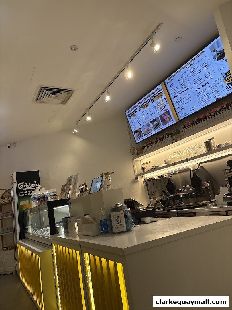 Interior view of a waffle shop counter with menus, waffle makers, and a display case.