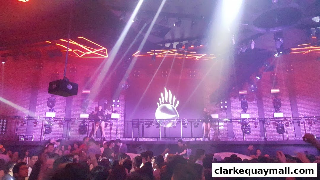 A lively nightclub scene with a DJ performing on stage and a crowd enjoying the music.