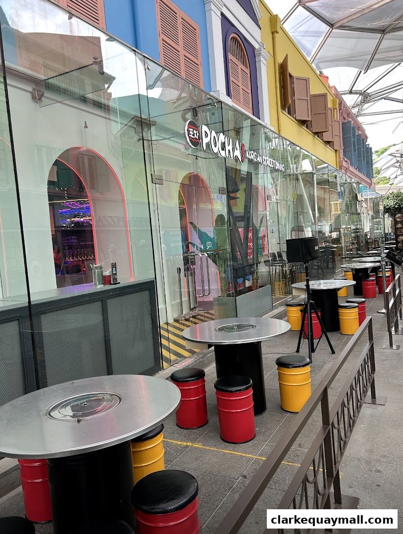 Exterior view of POCHA Korean Street Dining with outdoor seating and colorful building facade.
