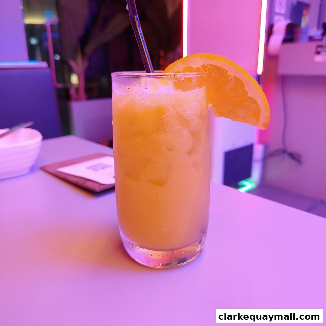 A refreshing orange juice with a slice of orange and a straw in a glass.