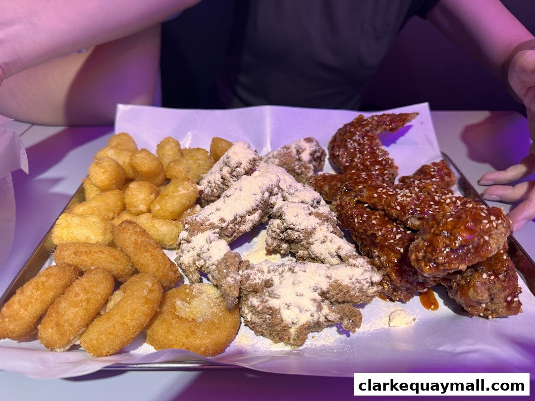 A platter of Korean fried chicken wings and tater tots served on a tray.