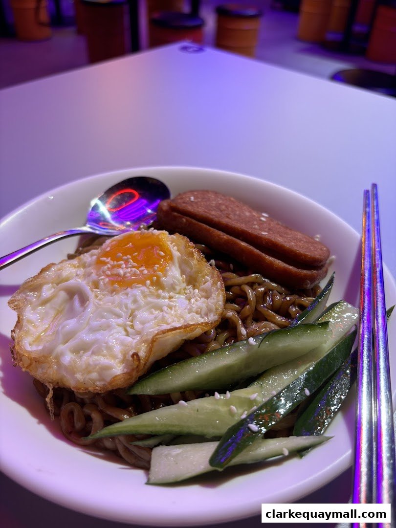 A bowl of Korean Jajangmyeon with fried egg, spam, and cucumber slices.