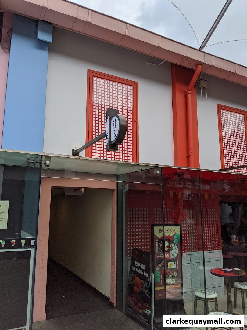 Exterior of a public toilet with a sign and an entrance leading downstairs.