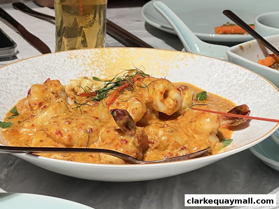 A close-up of a creamy seafood dish with prawns and calamari in a rich orange sauce.