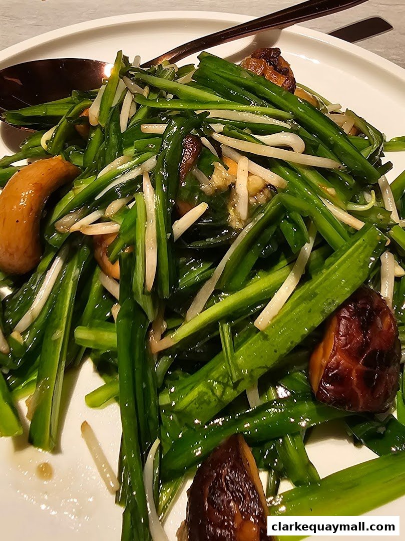 A close-up shot of a delicious stir-fried dish with green vegetables and mushrooms.