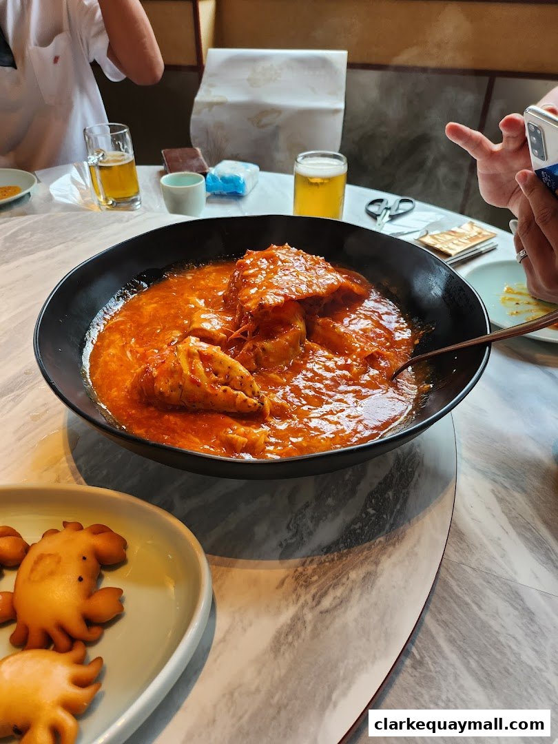 A close-up of a delicious seafood dish with crab in a rich sauce, served with drinks.