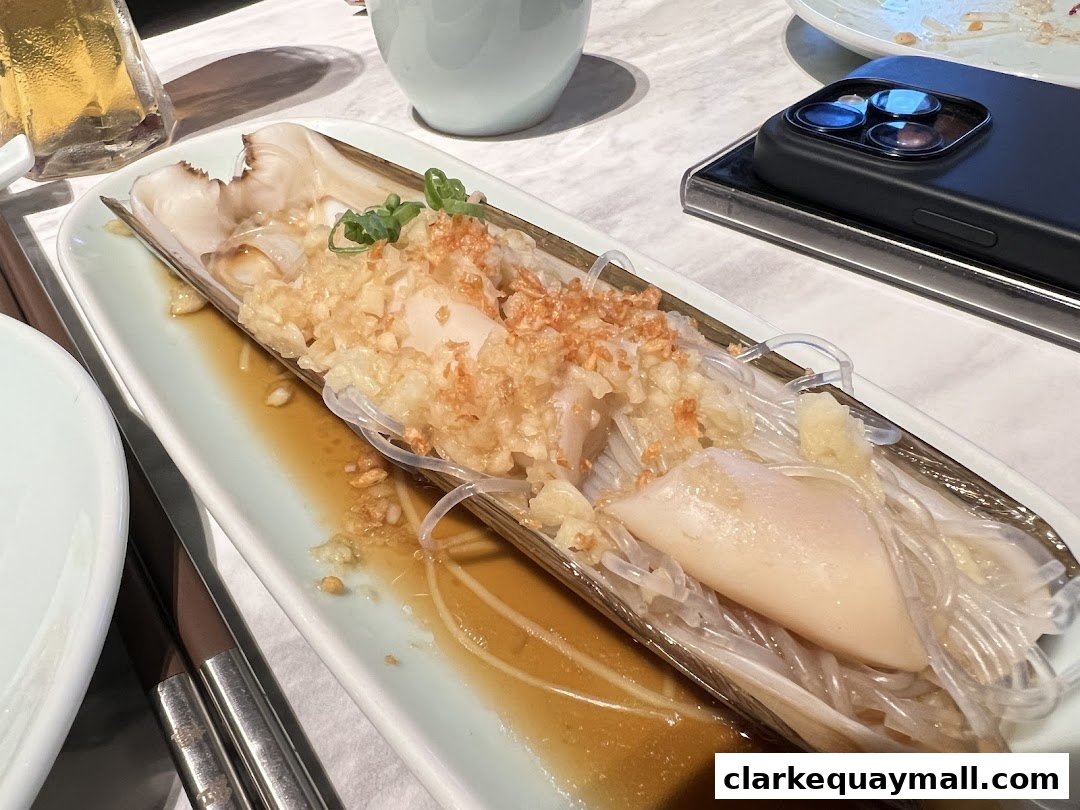 A plate of seafood with noodles and garlic, served in a long dish.